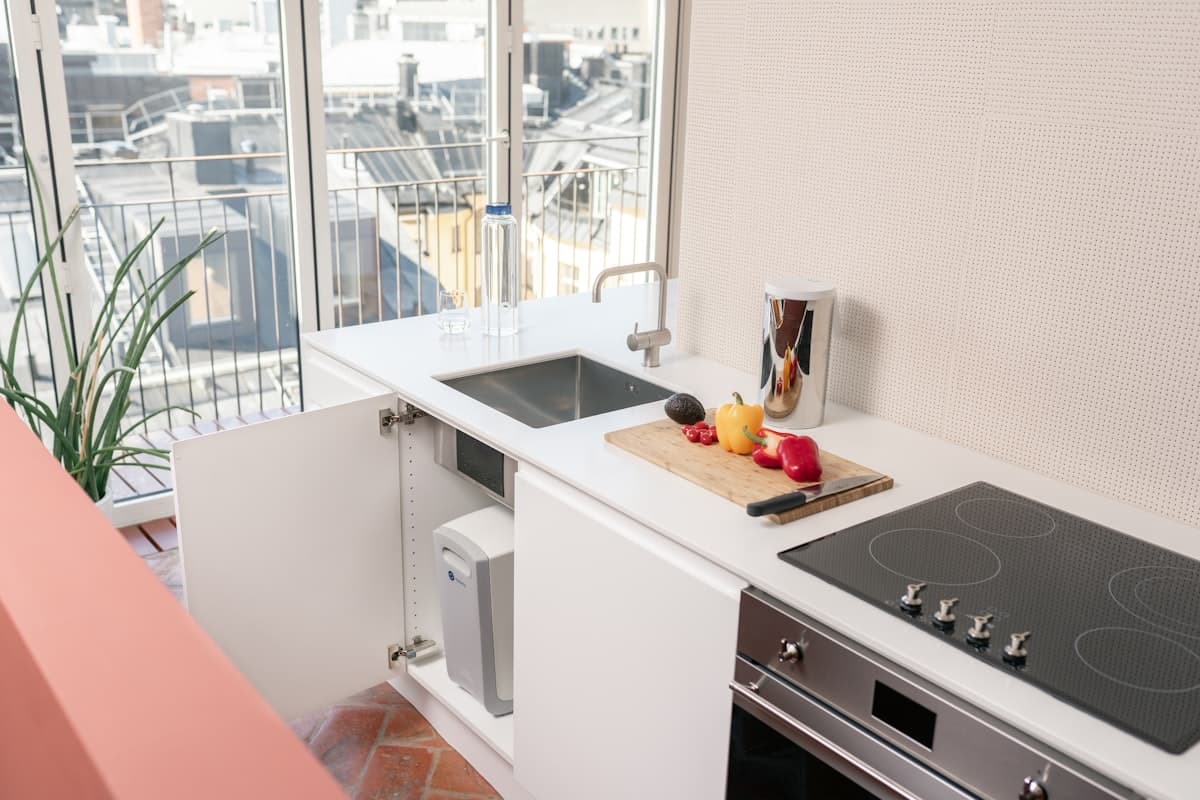 The Water Co System installed under a kitchen sink, with the dedicated RO faucet visible on the countertop. (Placeholder photo of an under-sink RO system.)