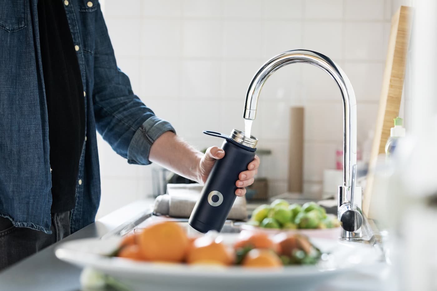Filling a water bottle from a clean kitchen tap