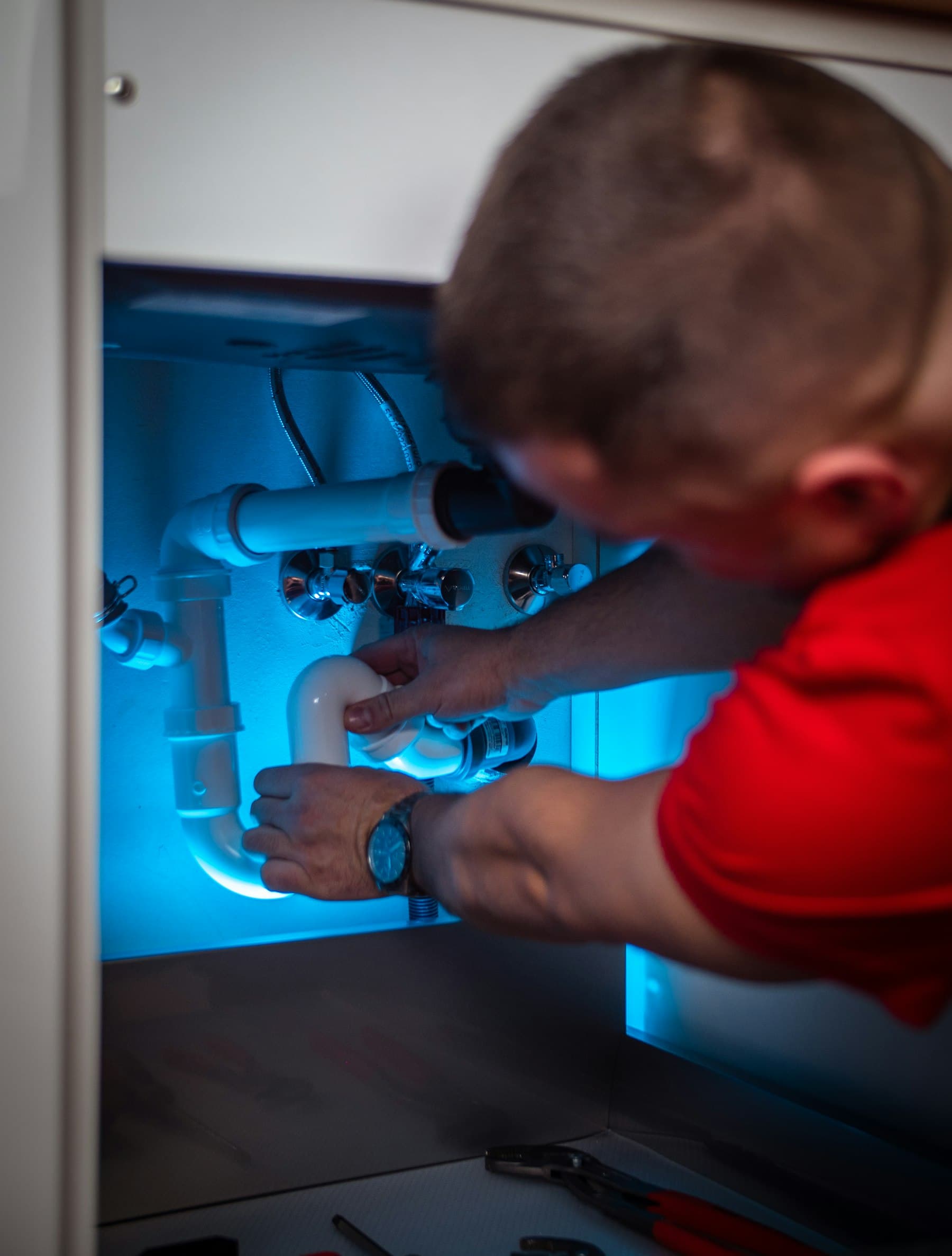 Under-sink view showing pipes, shutoff valves, and cabinet space