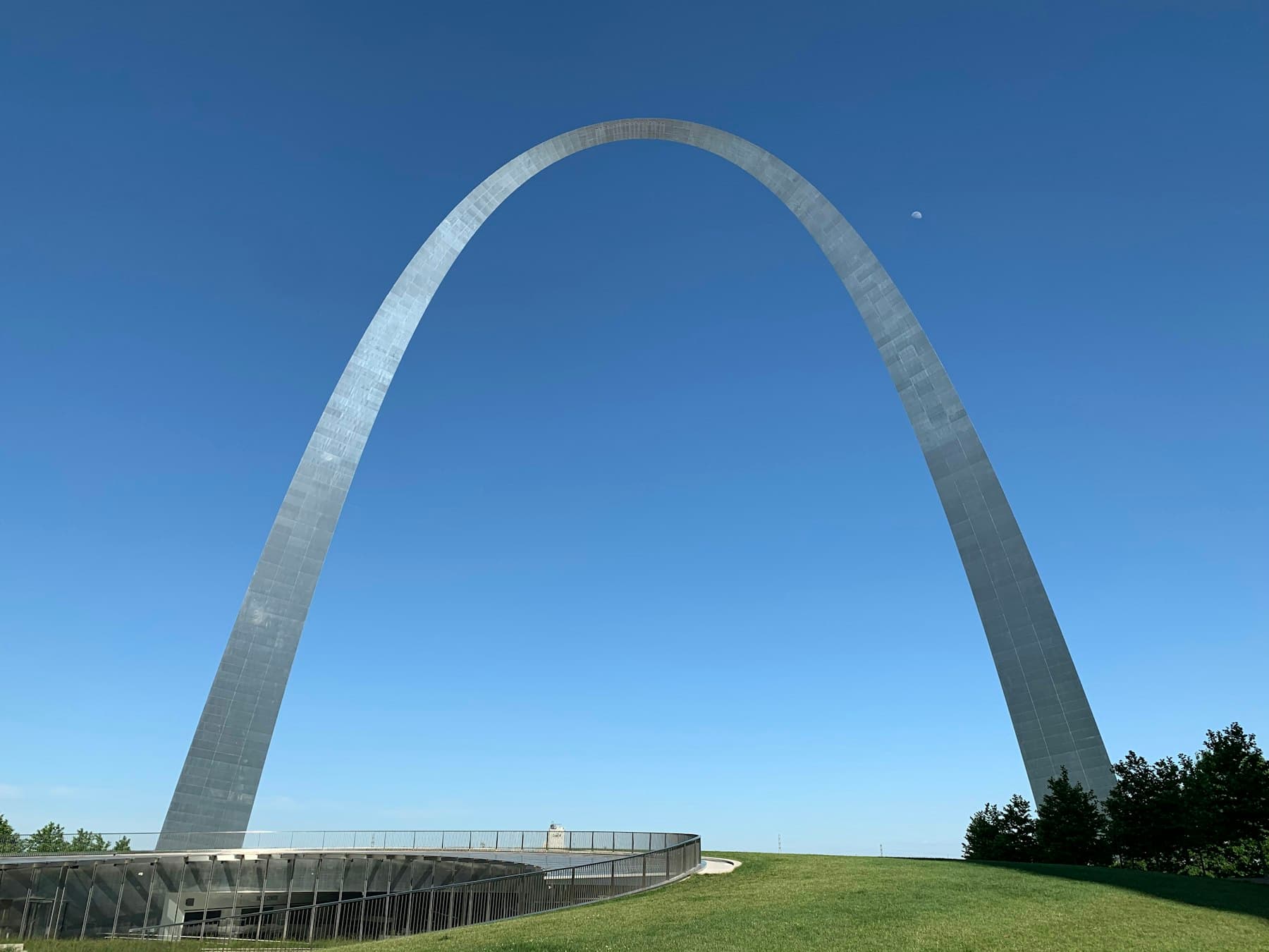 The Gateway Arch in St. Louis on a clear summer day, viewed from the grass at its base.