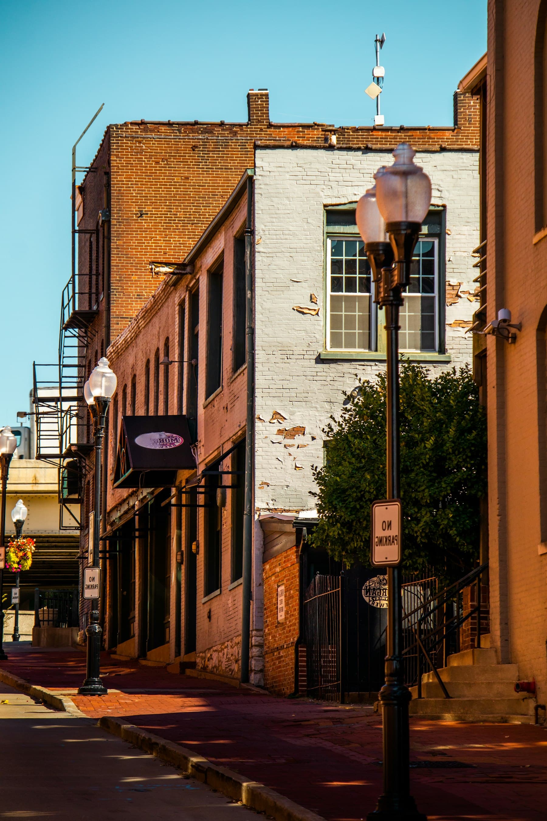 A historic brick street in St. Louis with a vintage lamp post and warm afternoon light.